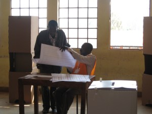 Consegna dell'enorme scheda a un elettore.